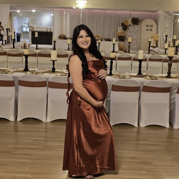 pregnant momma-to-be in elegant red dress fall baby shower theme with rectangular tables candle centerpieces