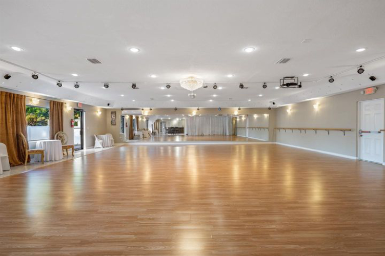 large open venue space with wood floor mirrors and curtain wall