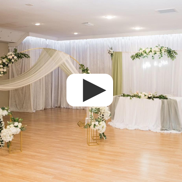 watch wedding reception with balloon arch white drapes white florals in from to white flown curtains